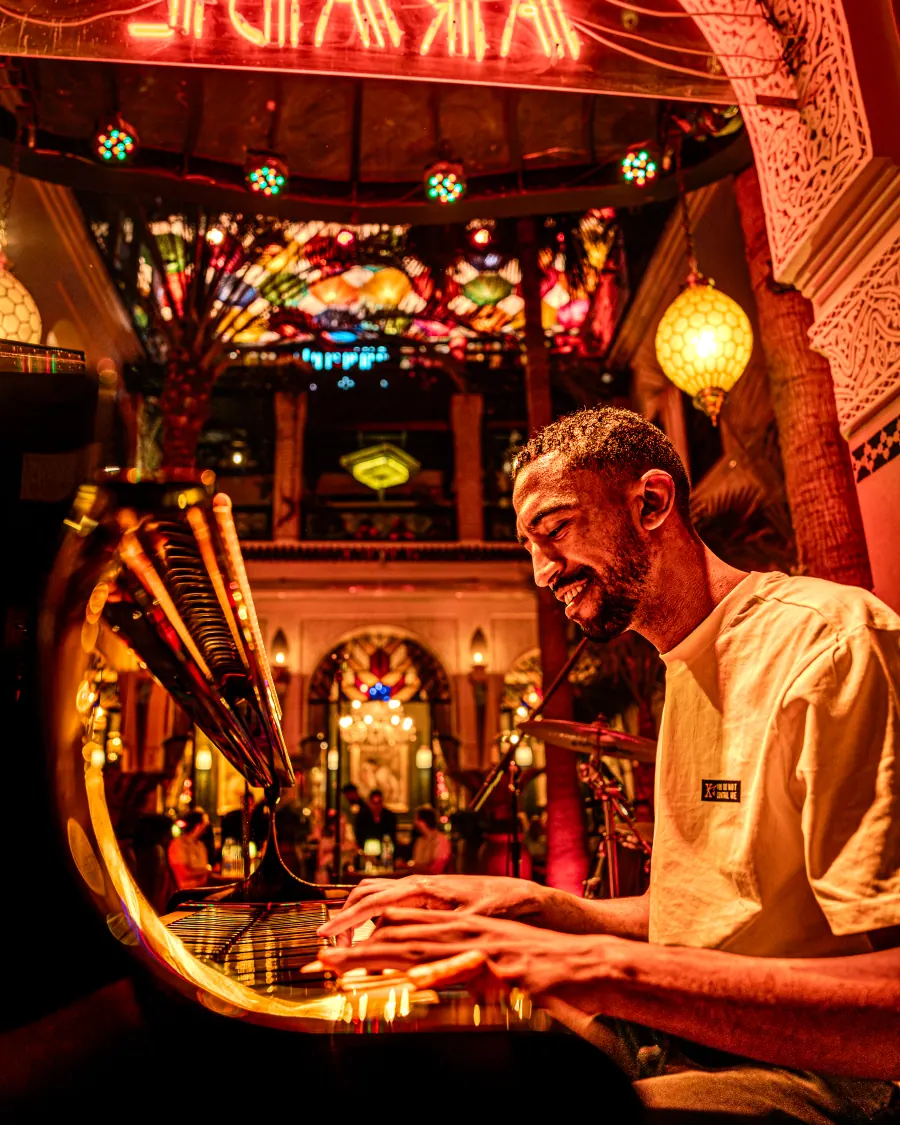 Musicien au clavier dans les lumières ambrées du Bistro Arabe