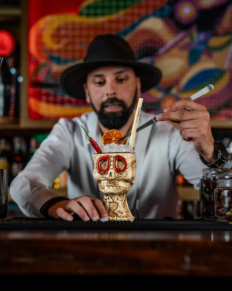 Bartender FavelaChic présentant un cocktail sculptural