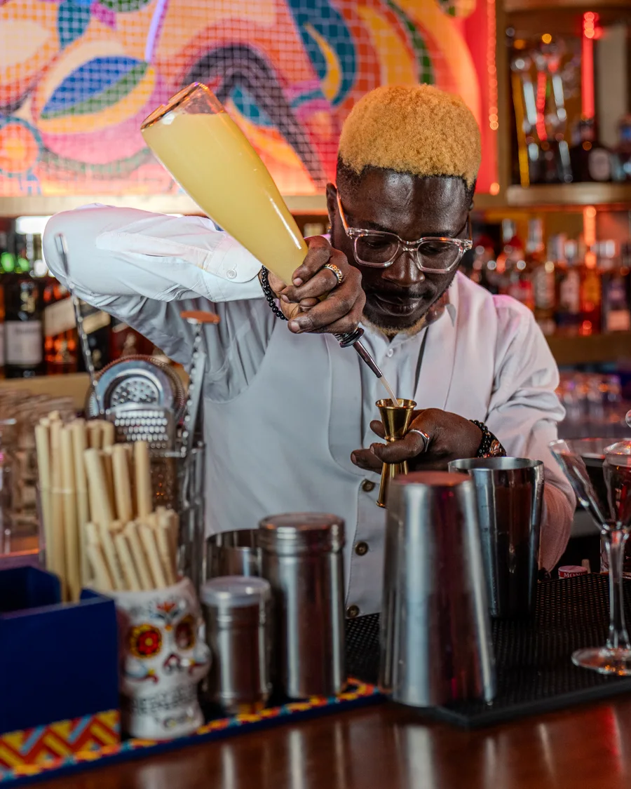 Bartender en action derrière le bar coloré