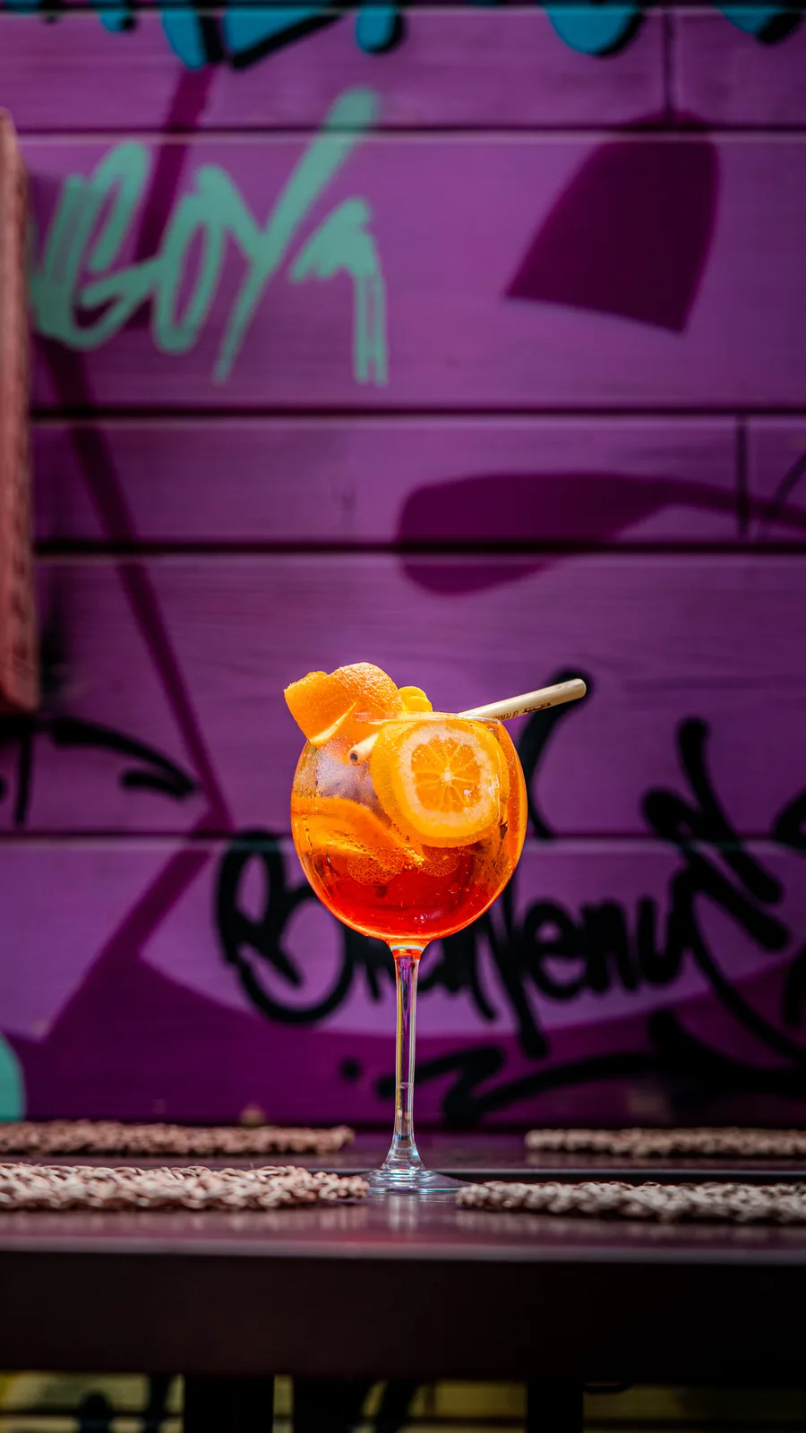 Cocktail orange devant le décor mural de La Pergola