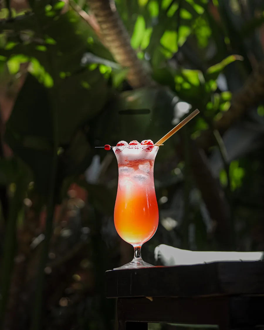 Cocktail rosé présenté dans un espace végétalisé