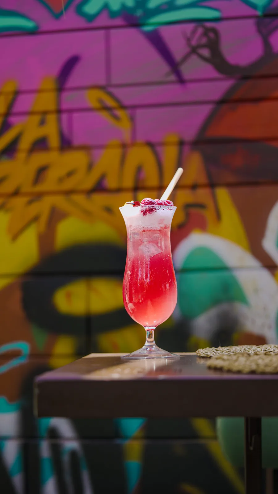 Cocktail rosé devant le mur graphique de La Pergola
